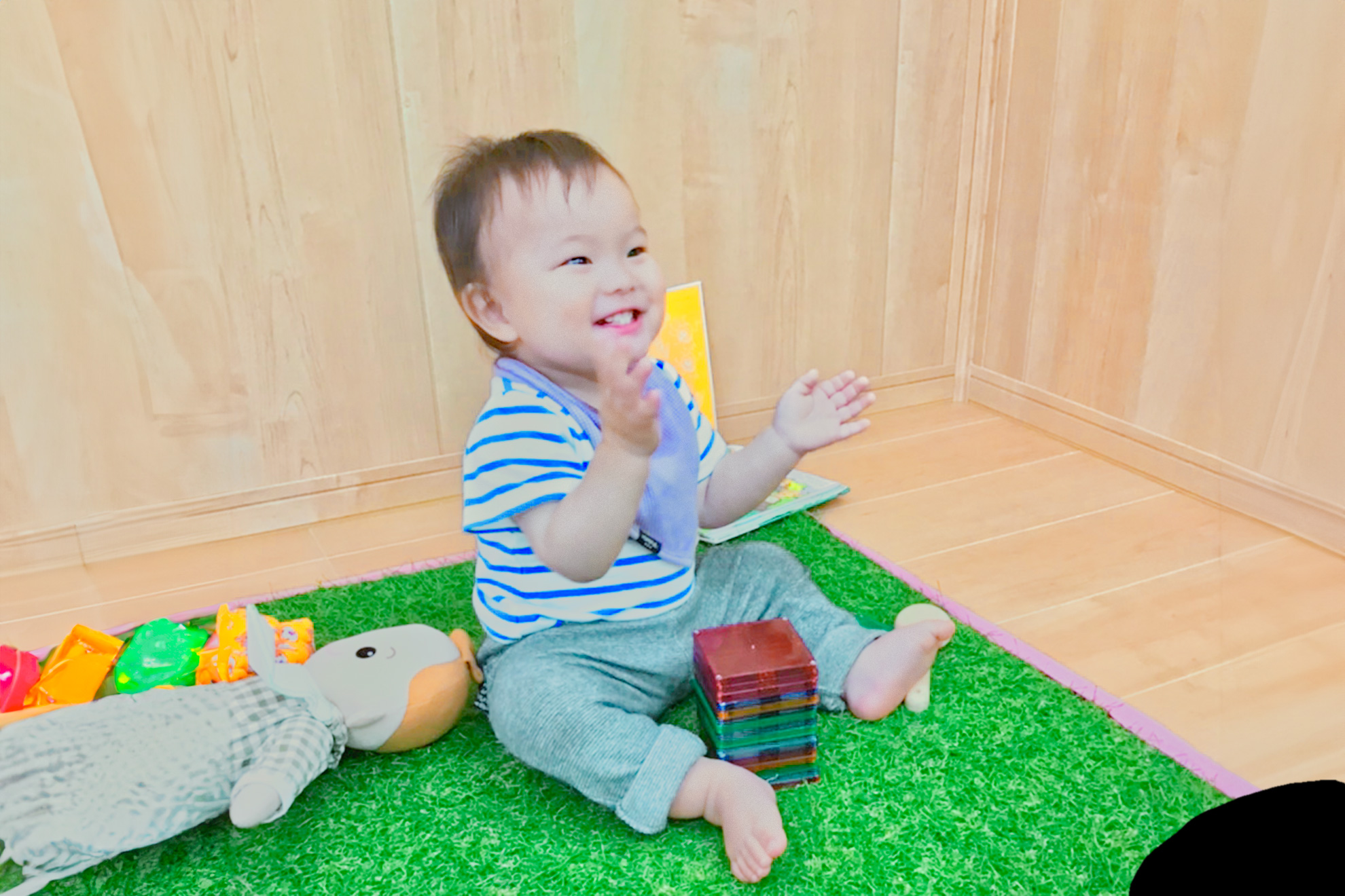 遊具の前で座って笑顔の園児